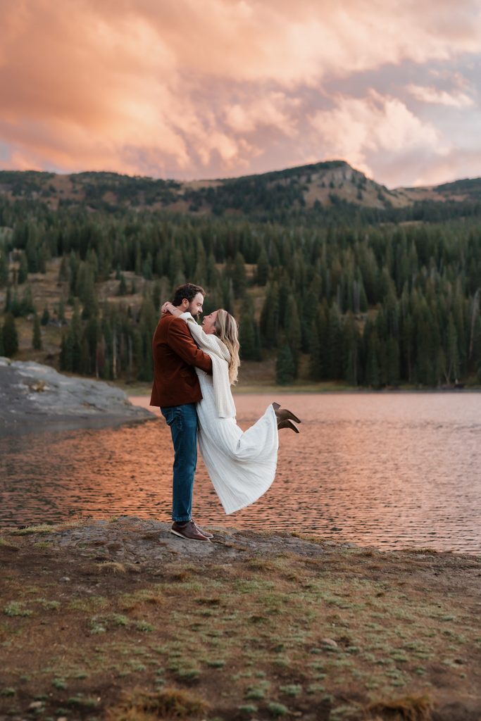 Colorado Engagement Session Locations Couple embracing at sunrise near a mountain lake in Crested Butte during their Colorado engagement session