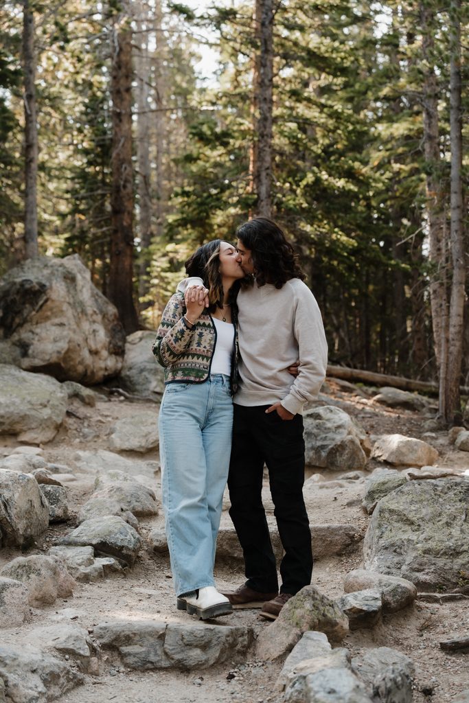 Colorado Engagement Session Locations Couple embracing near a wooden fence during their Rocky Mountain National Park Colorado engagement session