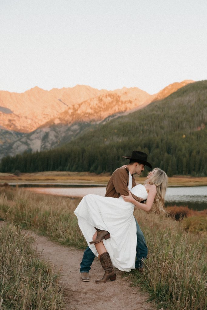 Colorado Engagement Session Locations Couple embracing on a rocky overlook above Piney Lake near Vail during Kylie and Luke's Colorado engagement session