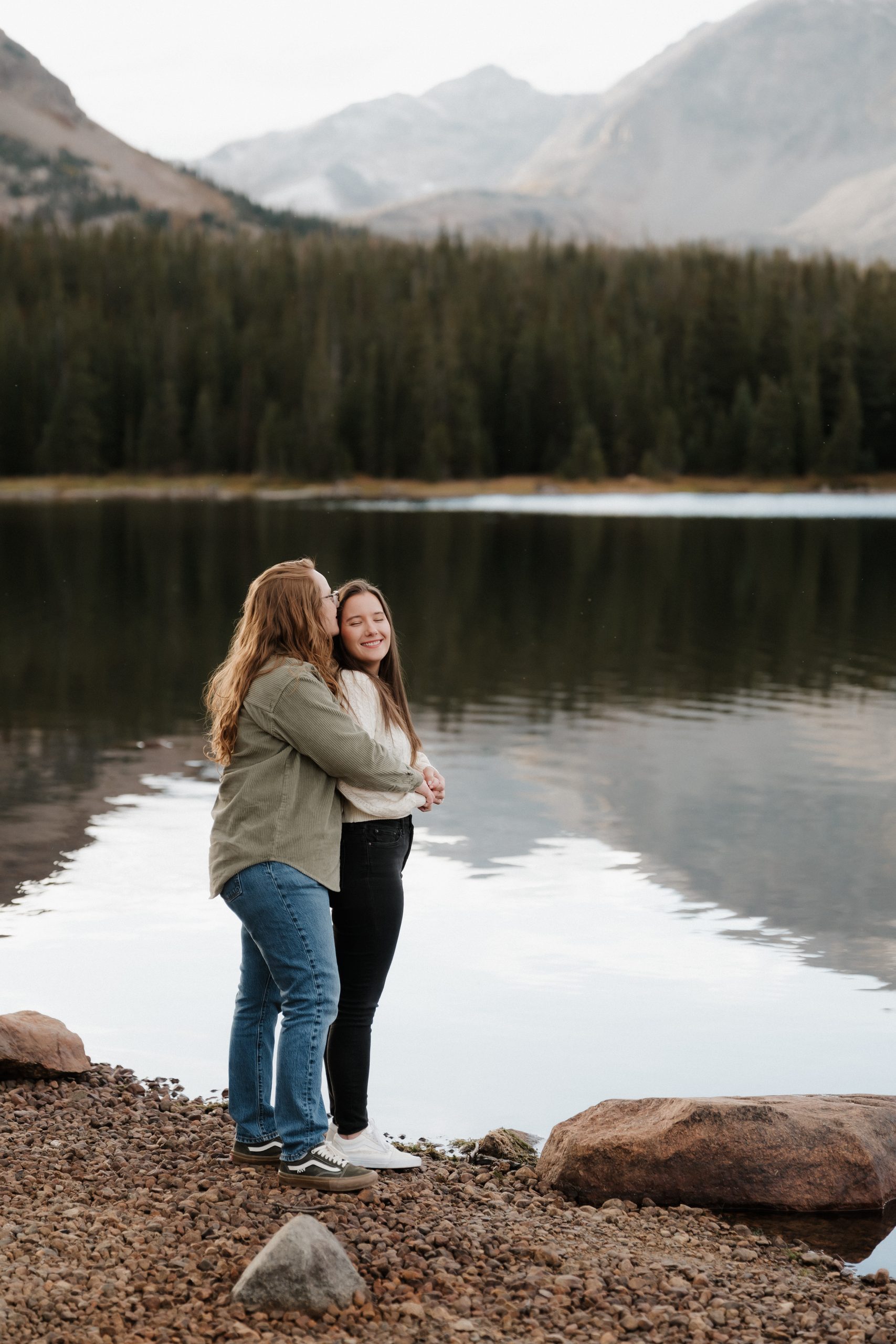 Colorado Engagement Session Locations Couple wrapped in a blanket beside Brainard Lake during their Colorado engagement session