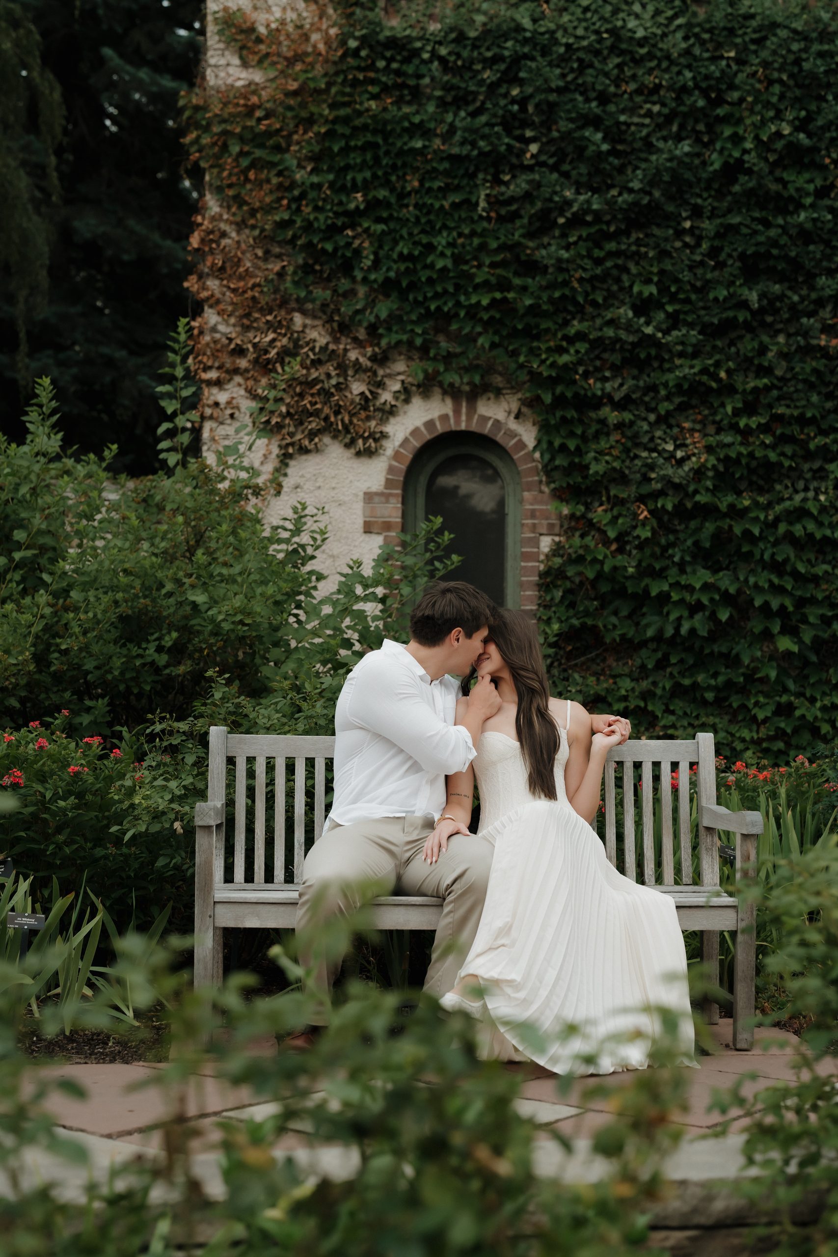 Colorado Engagement Session Locations Couple embracing beside a garden archway during their Denver Botanic Gardens Colorado engagement session