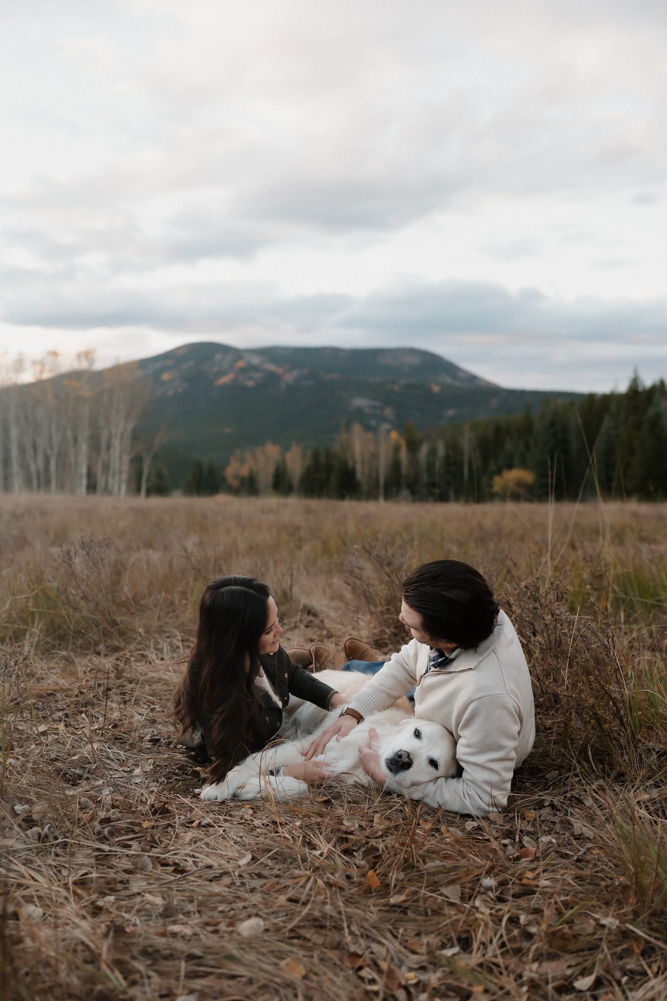 Colorado Engagement Session Locations Couple walking their dogs through a mountain meadow during their Echo Lake Colorado engagement session