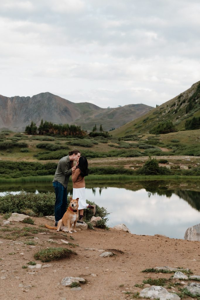 Colorado Engagement Session Locations Couple embracing near a mountain lake during their Loveland Pass Colorado engagement session