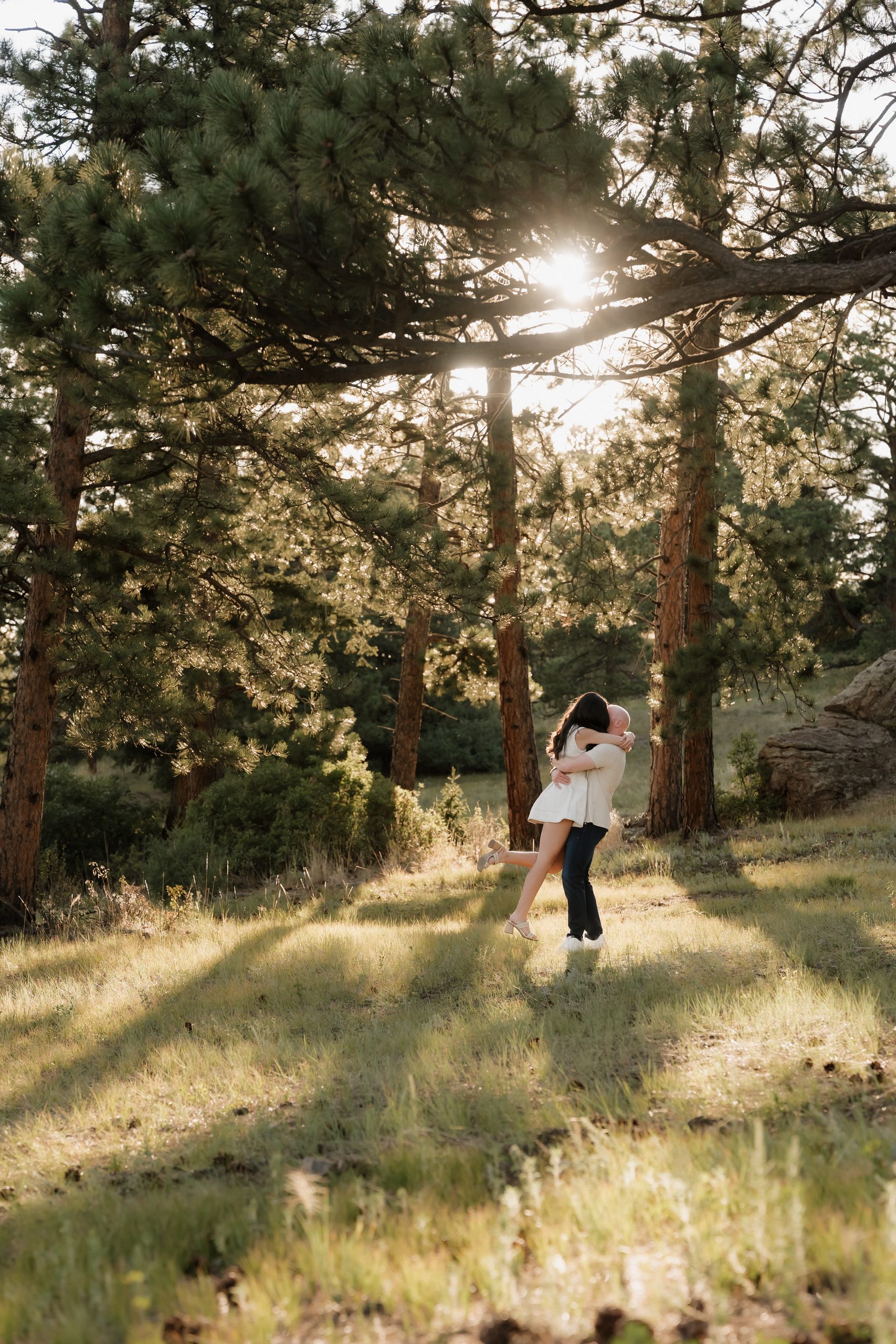 Colorado Engagement Session Locations Playful couple laughing together in the forest during their Mount Falcon Park Colorado engagement session