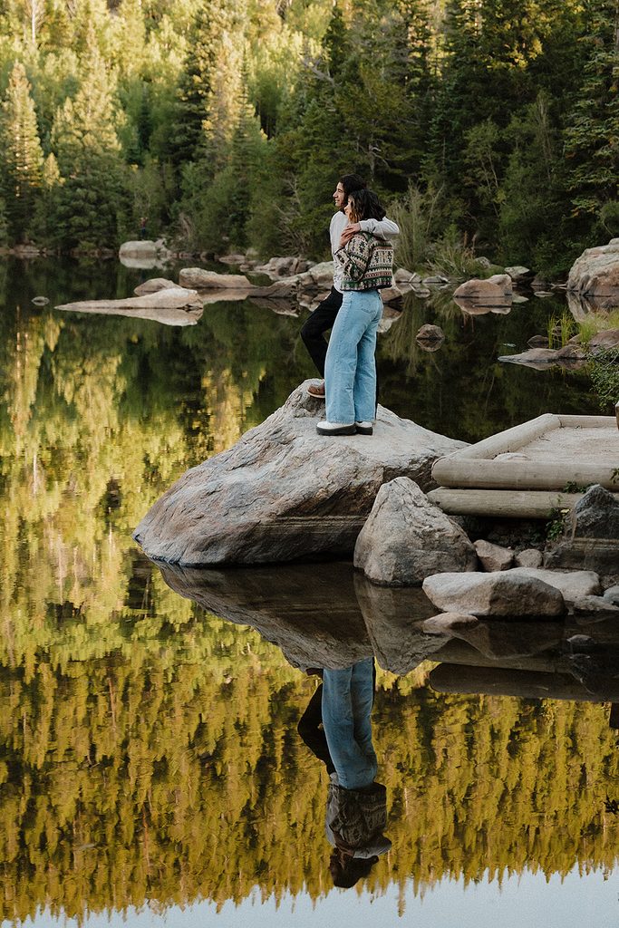 Rocky Mountain National Park elopement couple kissing on fallen log beside an alpine meadow stream